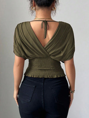 Army green ruched surplice dolman sleeve top with smocked waist and tie back detail.