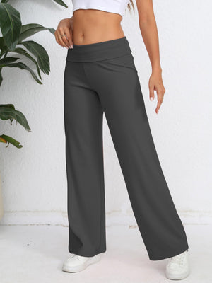 Dark gray palazzo trousers with a fold-over waistband and wide leg, styled with a white top.