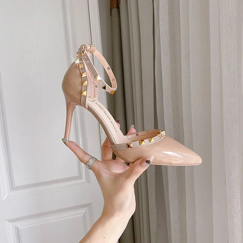 Apricot patent pumps with studded ankle strap and pointed toe.