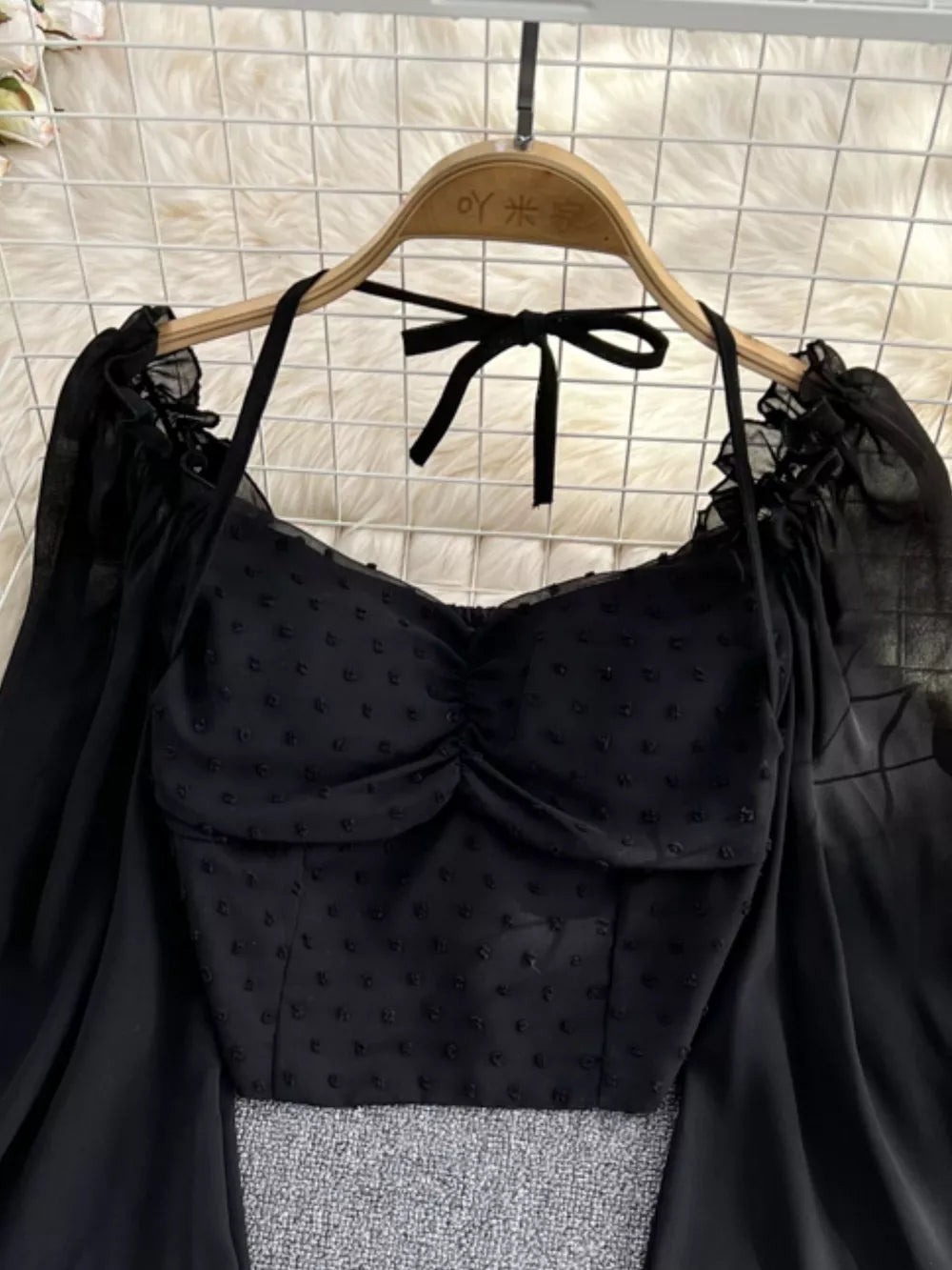 Black Swiss dot maternity blouse with ruffled neckline and tie halter.