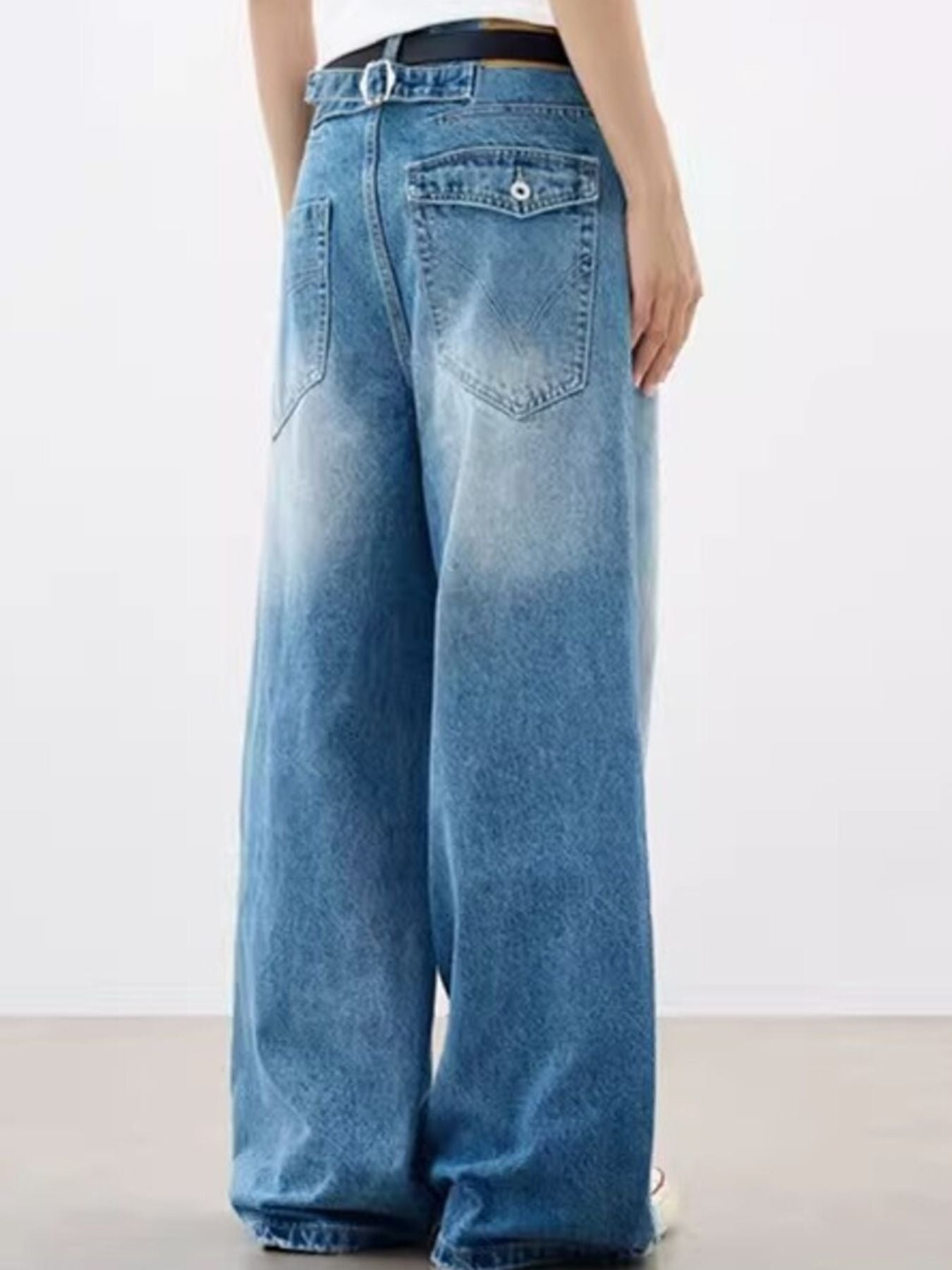 Relaxed fit vintage wash blue cotton jeans with pockets and a faded hem.