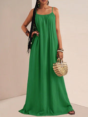Green maxi swim dress with gathered bust and spaghetti straps, flowing A-line skirt.