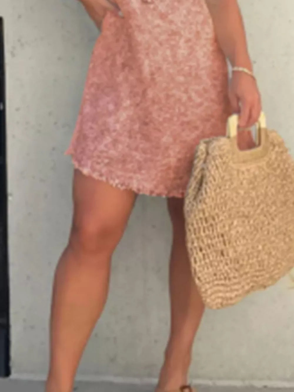 Coral floral print short sleeve above knee dress with frayed hem, styled with a straw bag.