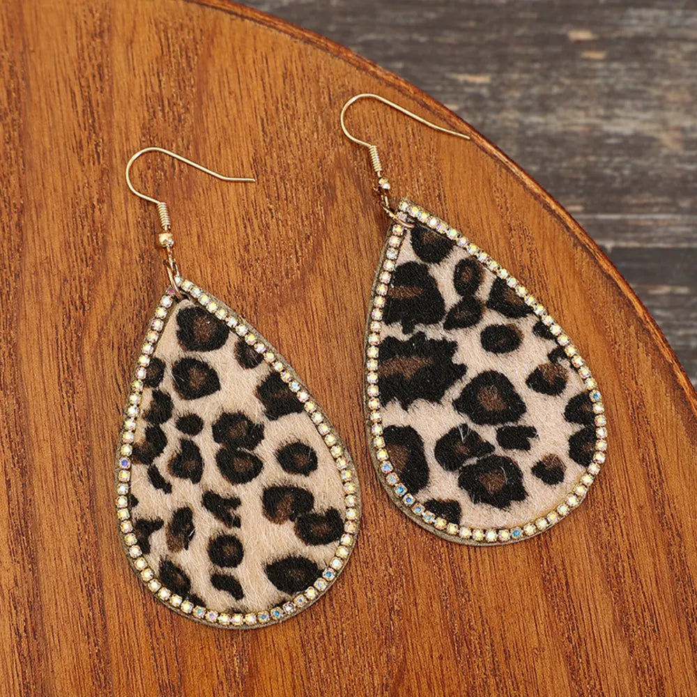 Leopard print teardrop earrings with crystal trim and gold hooks.