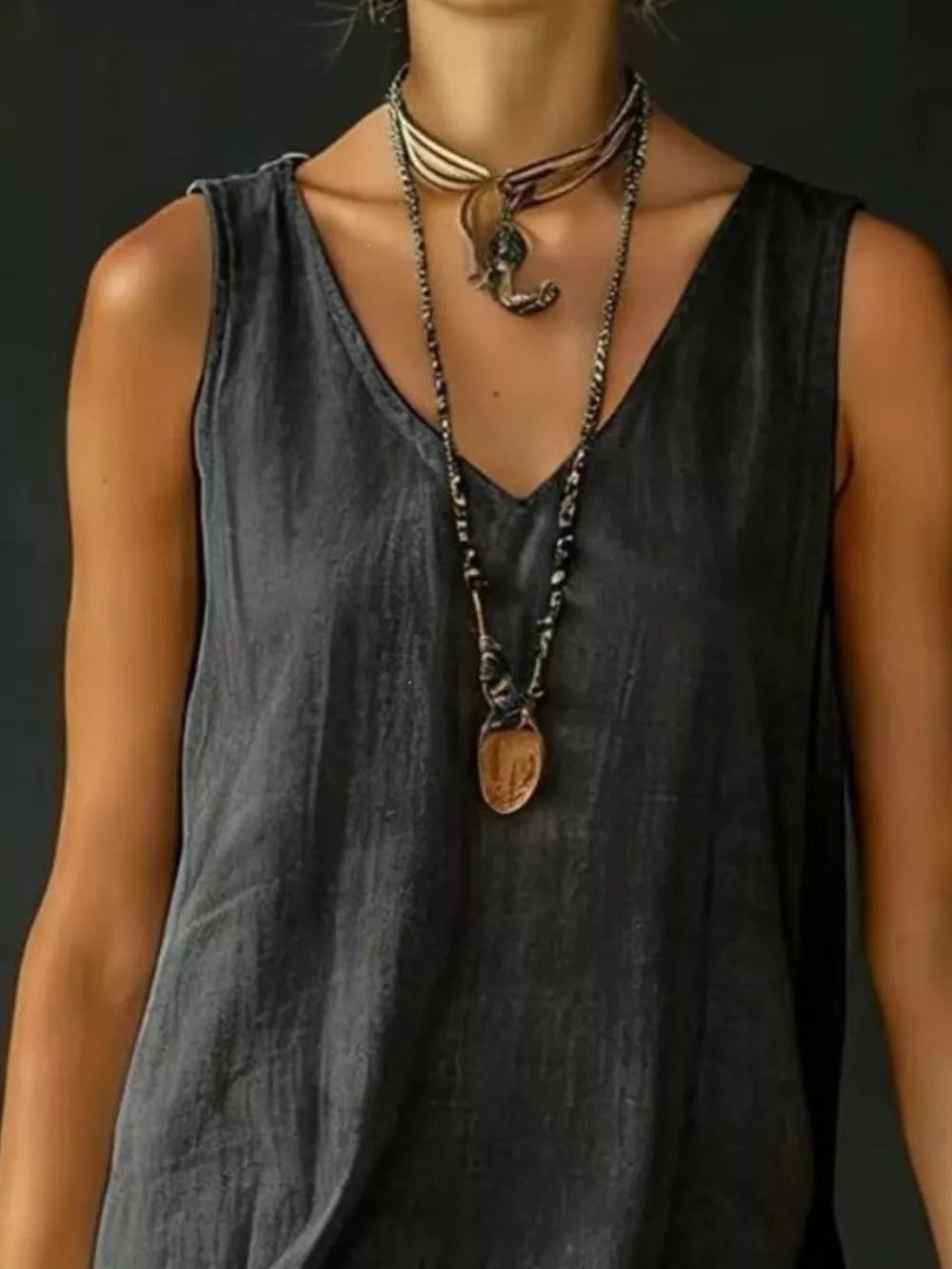 Grey V-neck sleeveless dress with tiered ruffled hem and layered necklaces.