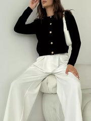 Black textured knit cardigan with elegant gold button detail and crew neck.