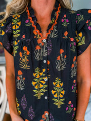 Black floral print maternity shirt with V-neck, button front, and orange frill detail.
