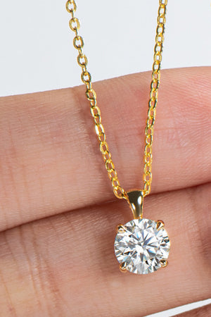 Gold chain necklace with a round solitaire diamond pendant.