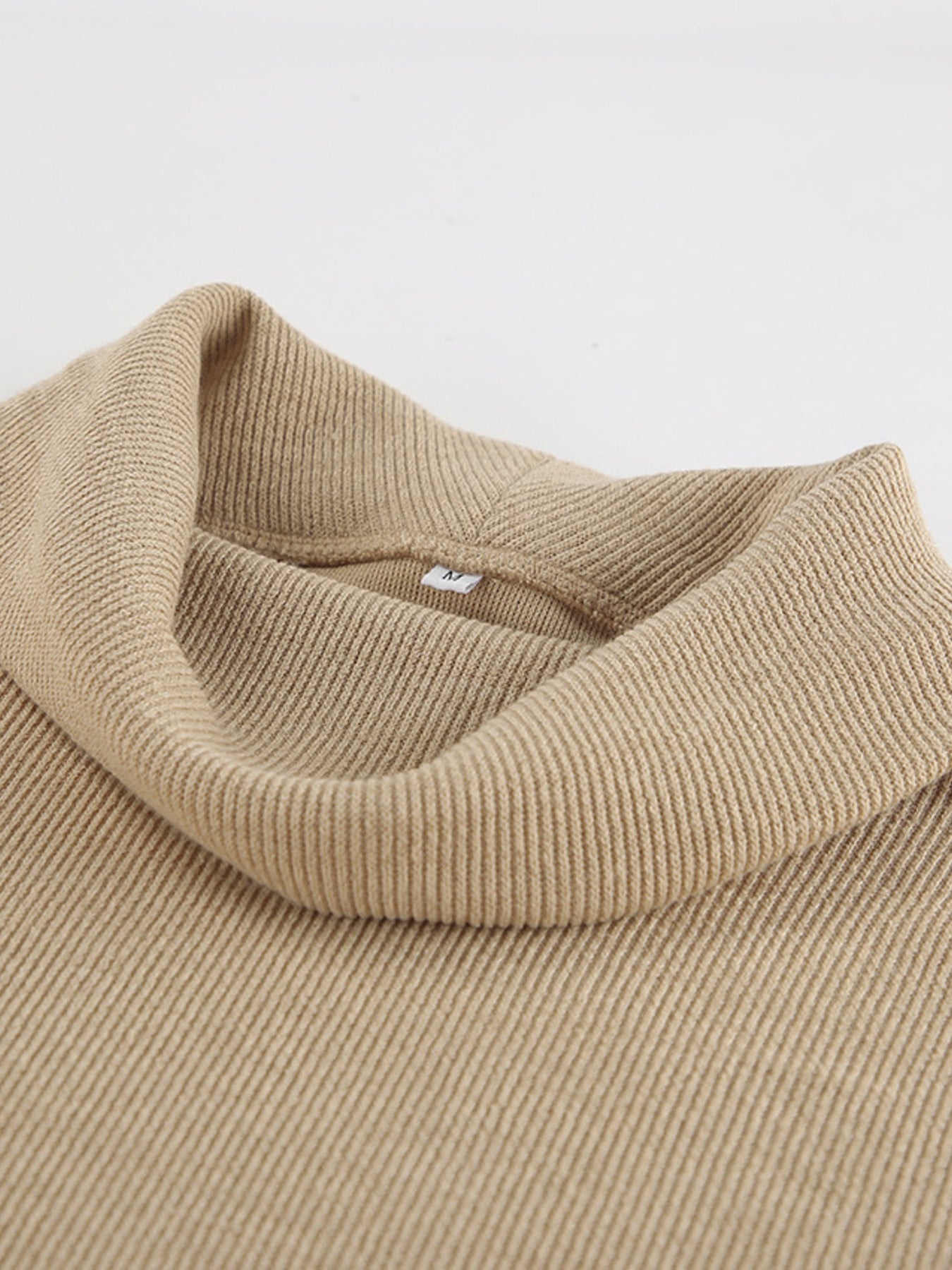 Beige ribbed cowl-neck turtleneck top with a relaxed fit.