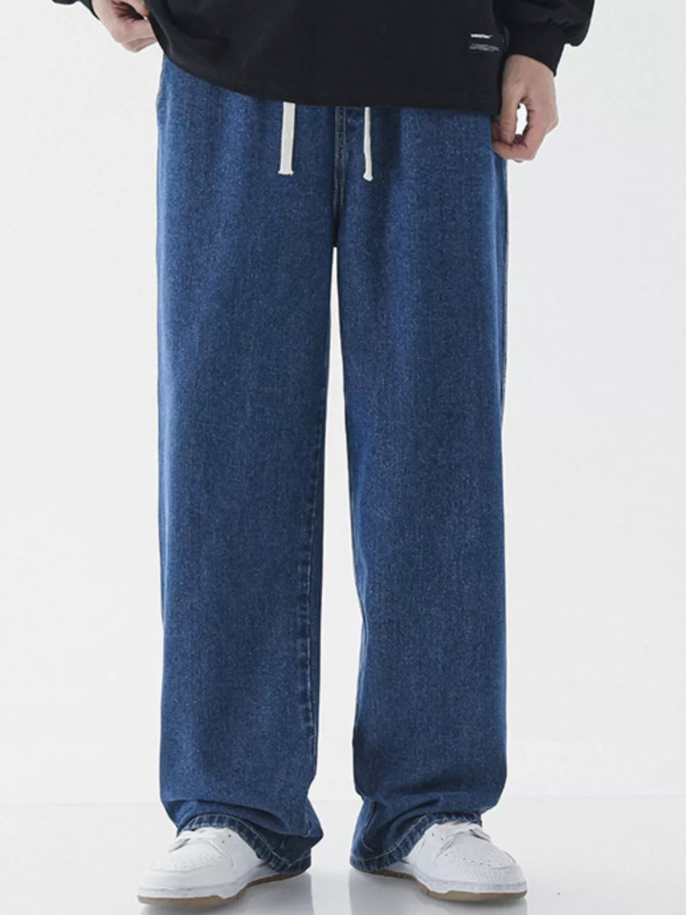 Relaxed wide-leg jeans in light blue denim with a white drawstring waist.