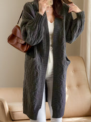Gray acrylic cable knit duster cardigan with pockets and balloon sleeves.