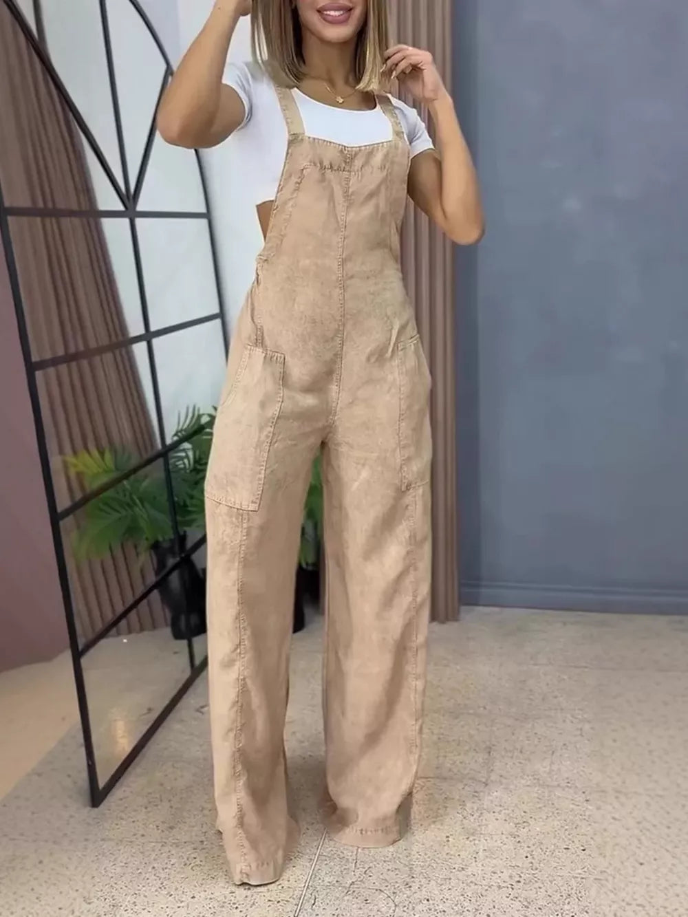 Khaki wide-leg denim overalls with bib front and large front pockets.