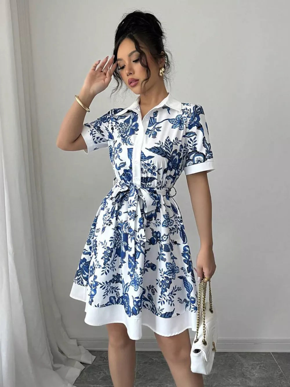 White and blue floral print mini dress with tie belt and short sleeves.