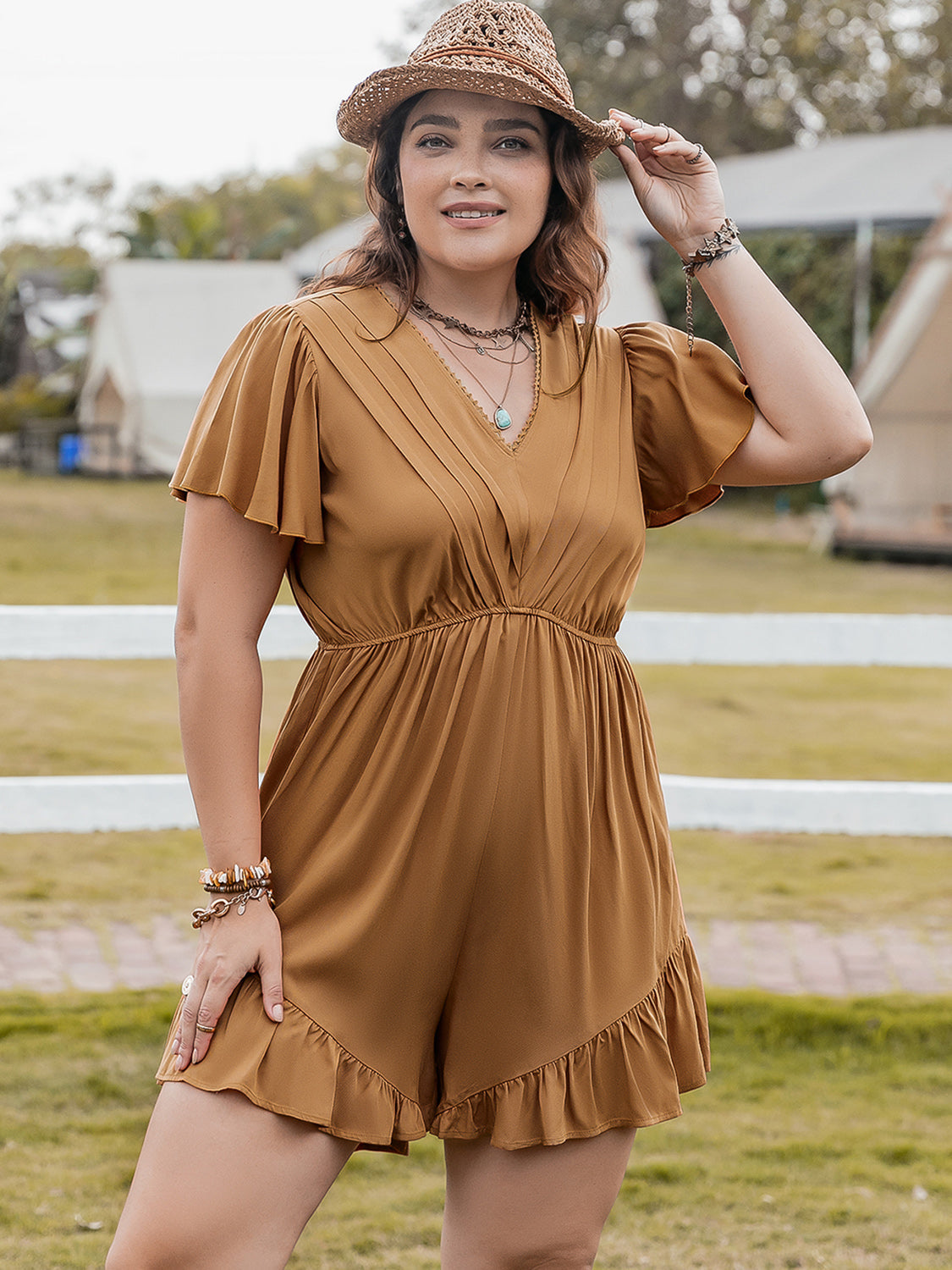Caramel pleated bodice romper with flutter sleeves and ruffle hem shorts.