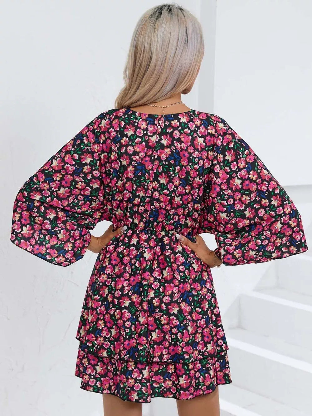Black floral mini dress with ruffle hem and bell sleeves.