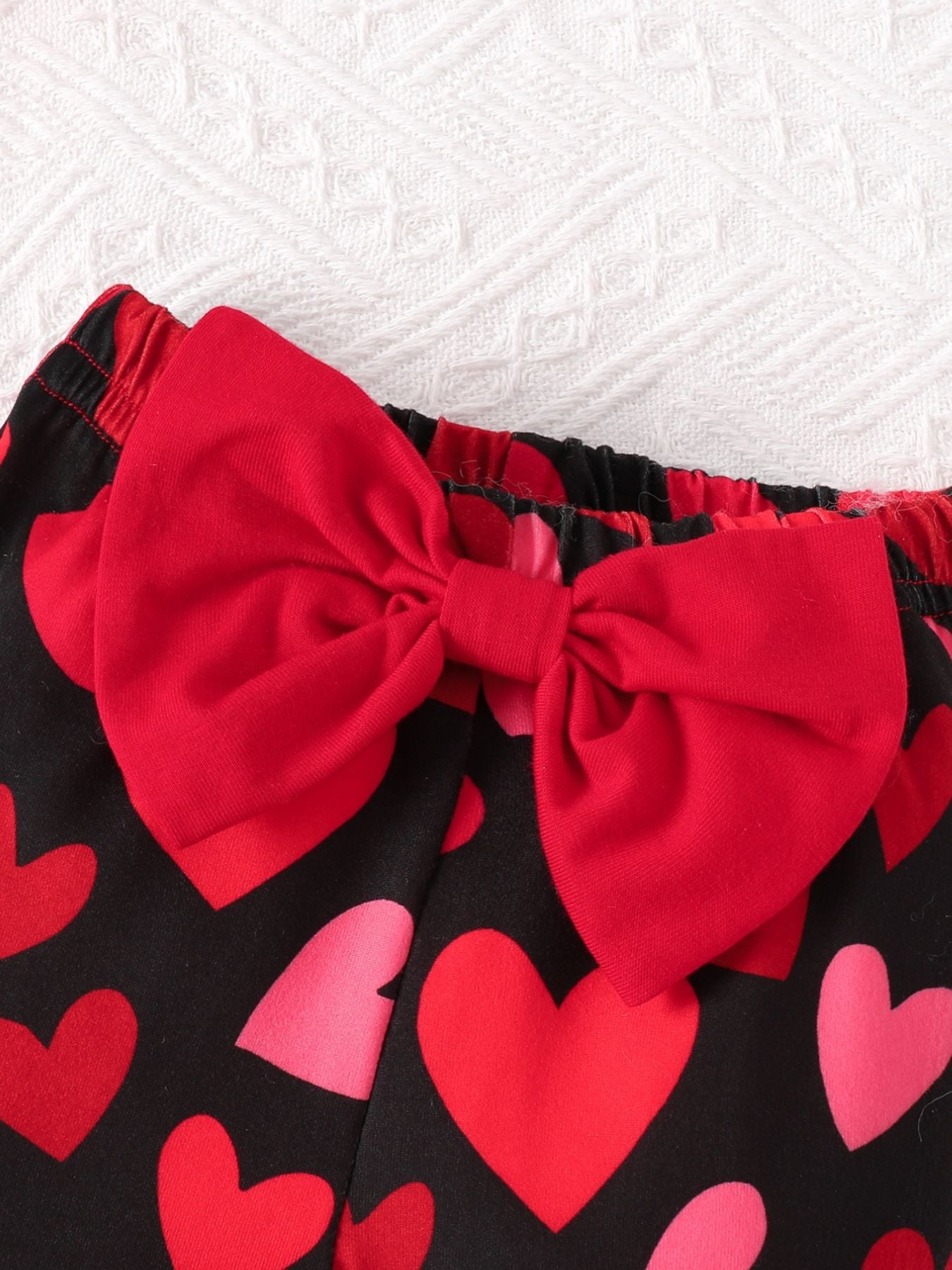 Baby pants with black heart print and red bow detail