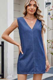 Sleeveless dark wash denim mini dress with V-neck and contrast stitching.