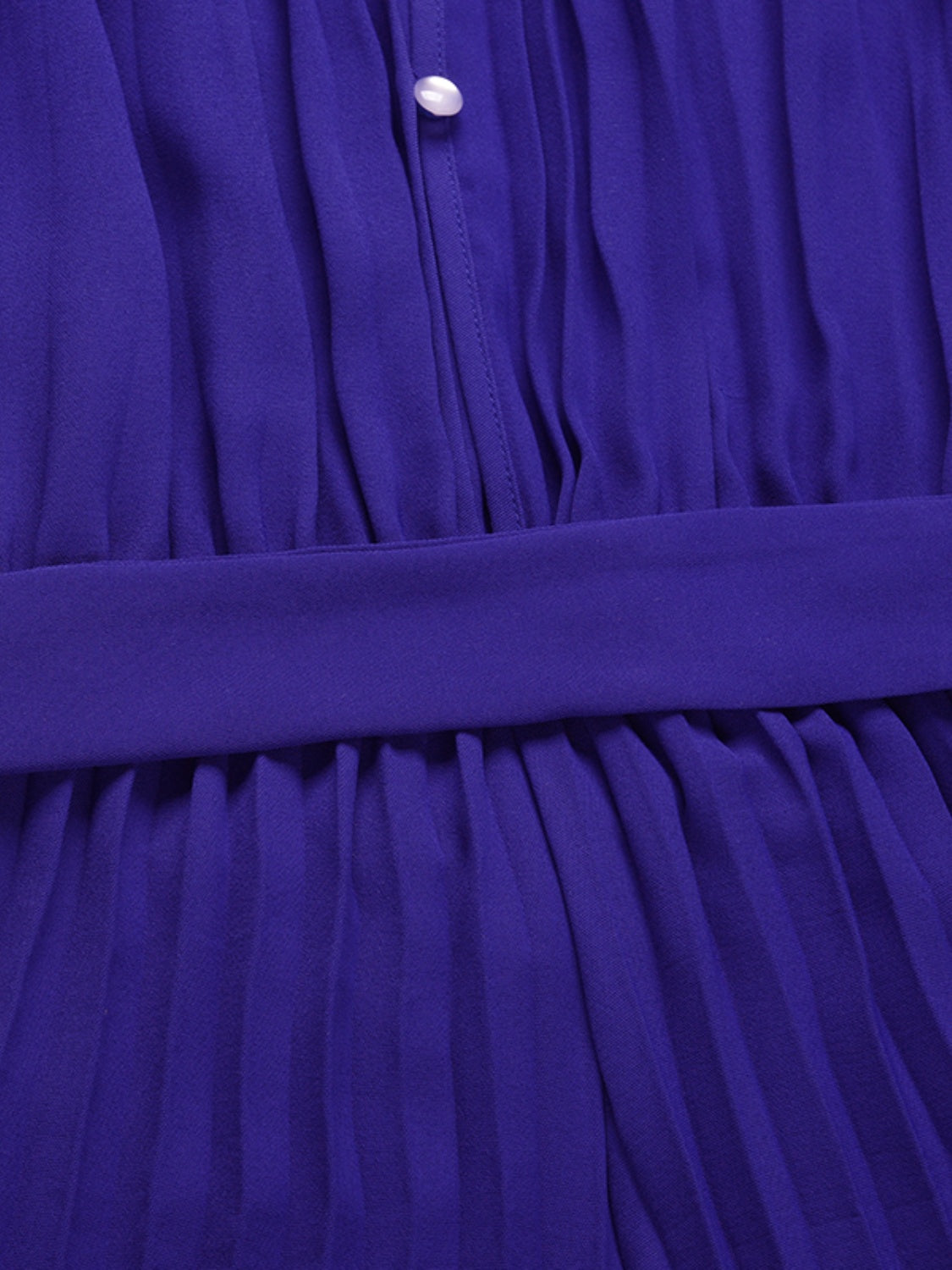 Halter neckline pleated palazzo jumpsuit in dark blue with a belted waist and button detail.