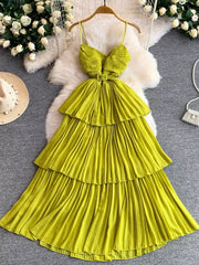Yellow belted pleated midi dress with spaghetti straps and tiered skirt.