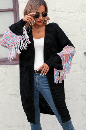 Black knit cardigan with colorful textured sleeve fringe detail and tasseled hem.