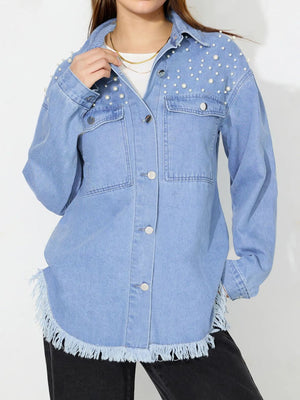 Light wash denim shirt with pearl embellishments on shoulders, frayed hem, and button front.