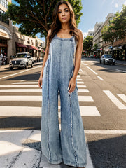Washed denim palazzo dungaree in light blue with raw seam details and wide legs.