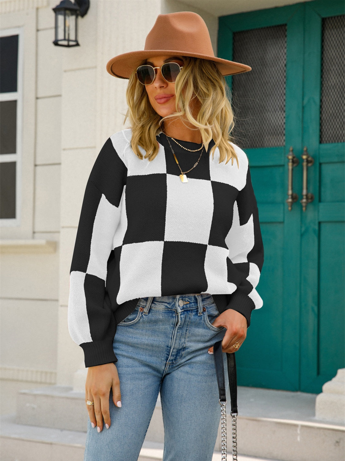 Checkerboard knit pullover sweater with balloon sleeves in black and white.
