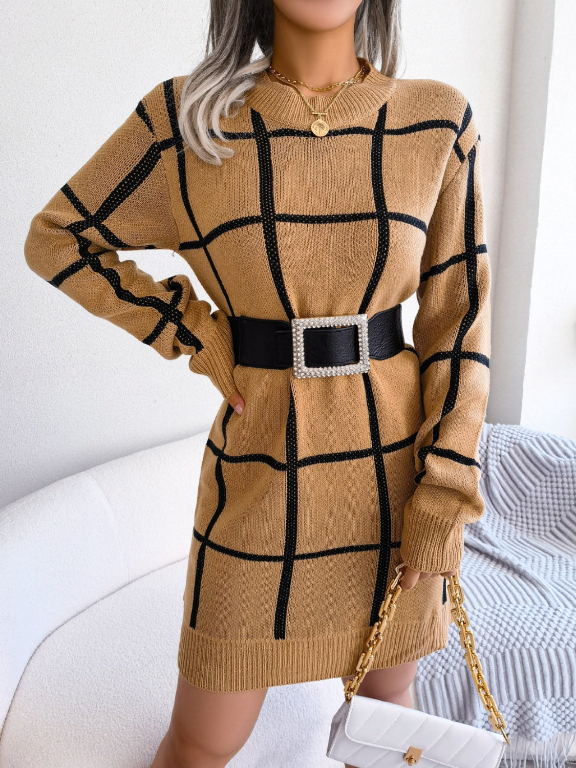 Khaki geometric grid knit mini dress with long sleeves and crew neck, styled with a black belt.