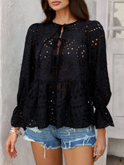 Black eyelet embroidered peplum blouse with tie neck and ruffled cuffs.
