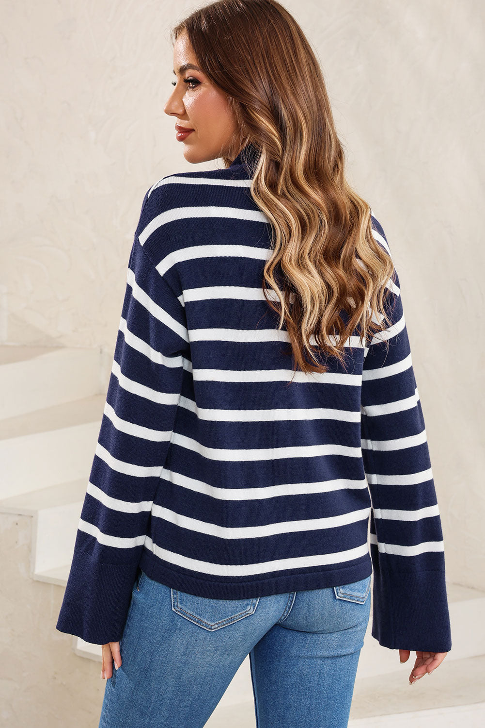 Navy and white striped knit sweater with mock neck and bell sleeves.