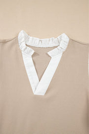 Khaki blouse with white contrast ruffle collar and V-neck detail.