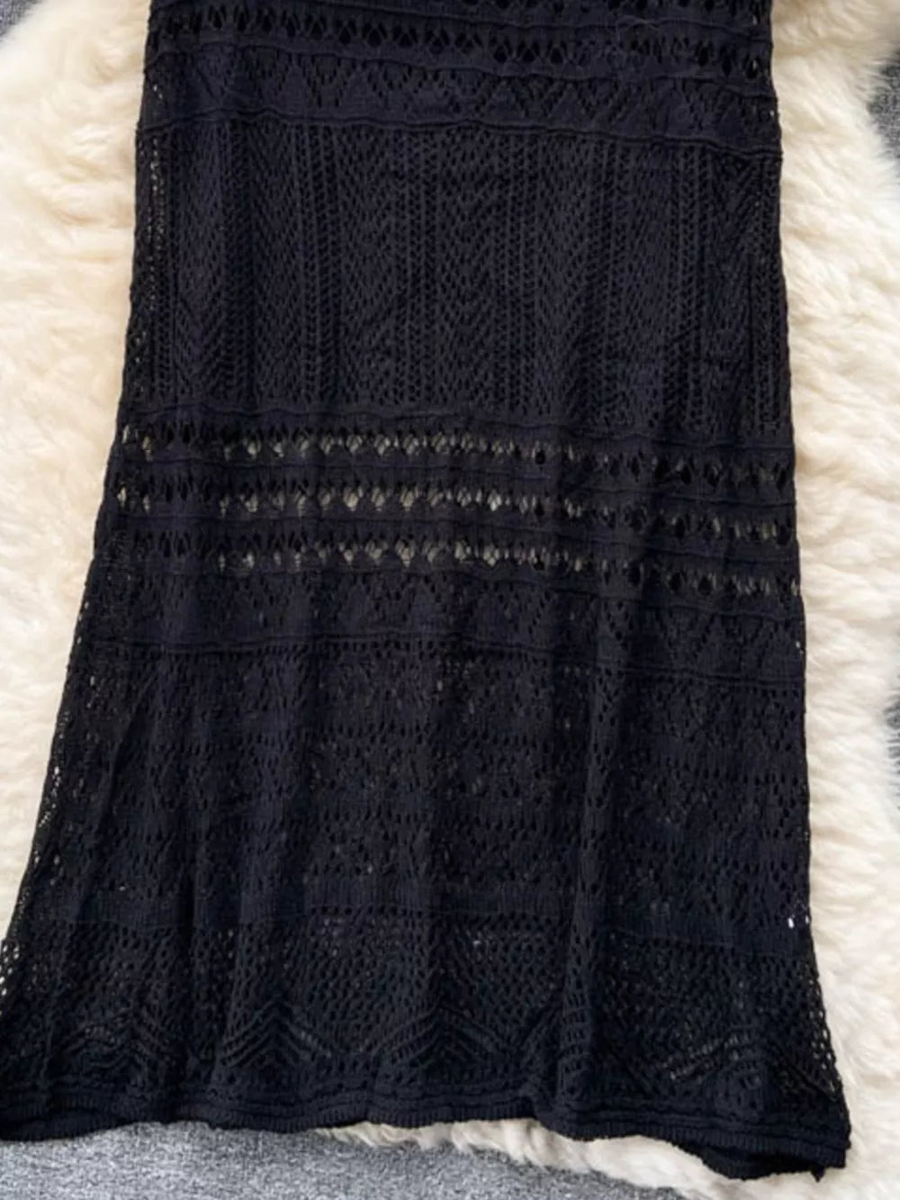 Black openwork maxi skirt with intricate woven details and a delicate crochet pattern.