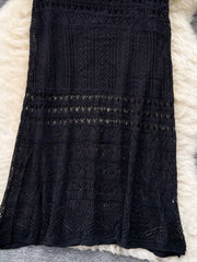 Black openwork maxi skirt with intricate woven details and a delicate crochet pattern.