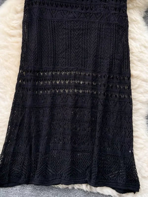 Black openwork maxi skirt with intricate woven details and a delicate crochet pattern.