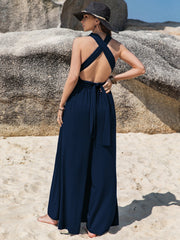 Dark blue halter neck wide leg jumpsuit with crisscross back and tie detail.