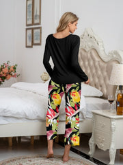 Botanical print lounge set with long sleeve black top and cropped pants.