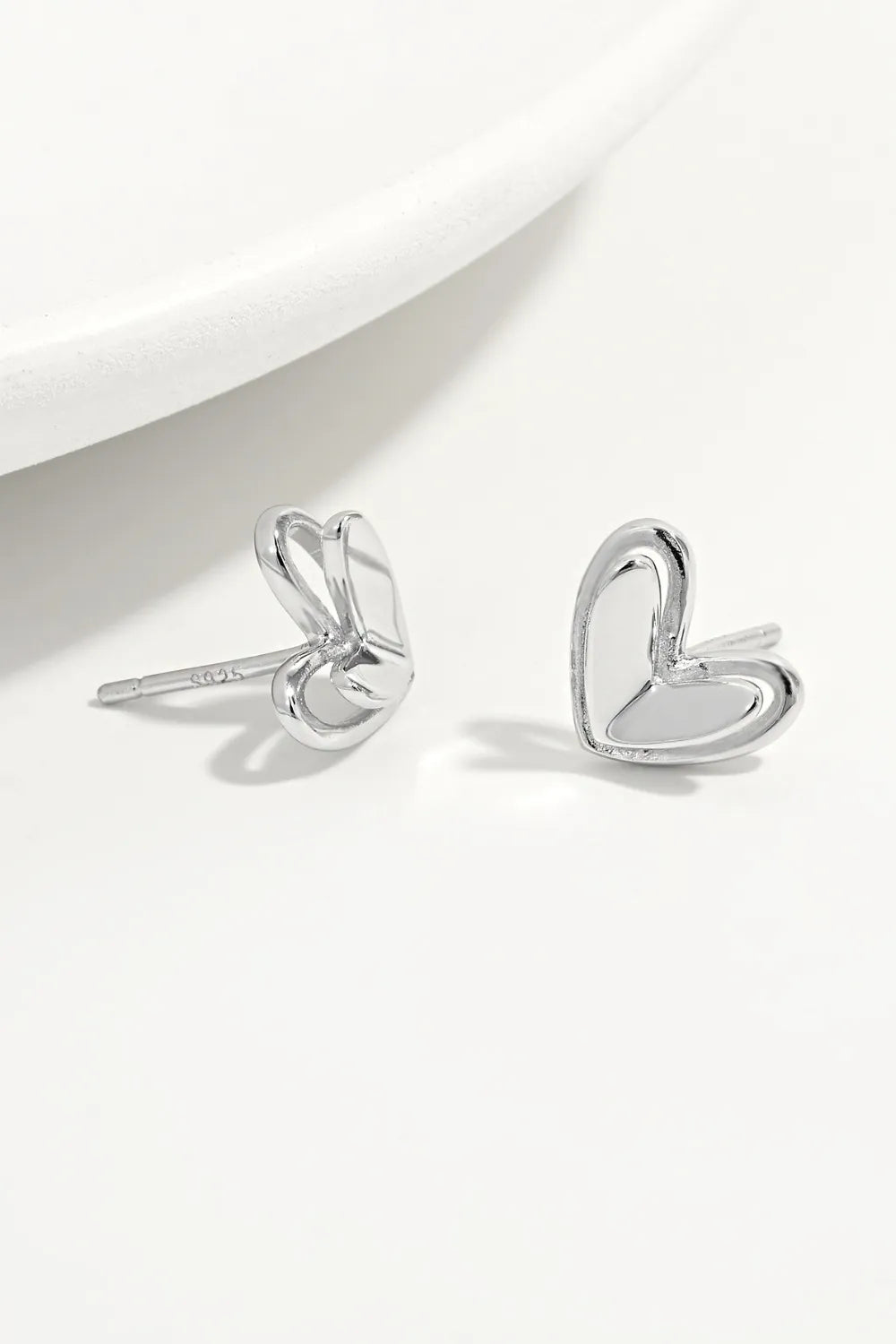 Silver open heart stud earrings with delicate double outline detail.