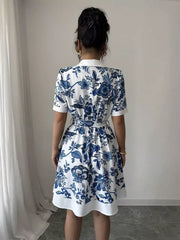 Floral print mini dress in white with blue pattern, tie belt, and short sleeves.