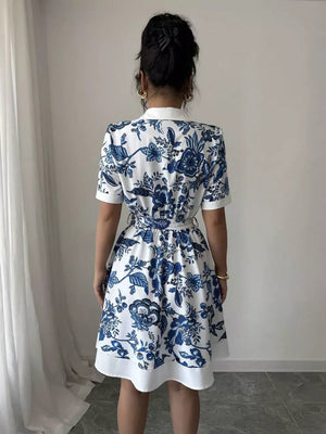 Floral print mini dress in white with blue pattern, tie belt, and short sleeves.