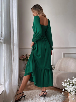 Green midi dress with smocked bodice, puff sleeves, and ruffled hem.