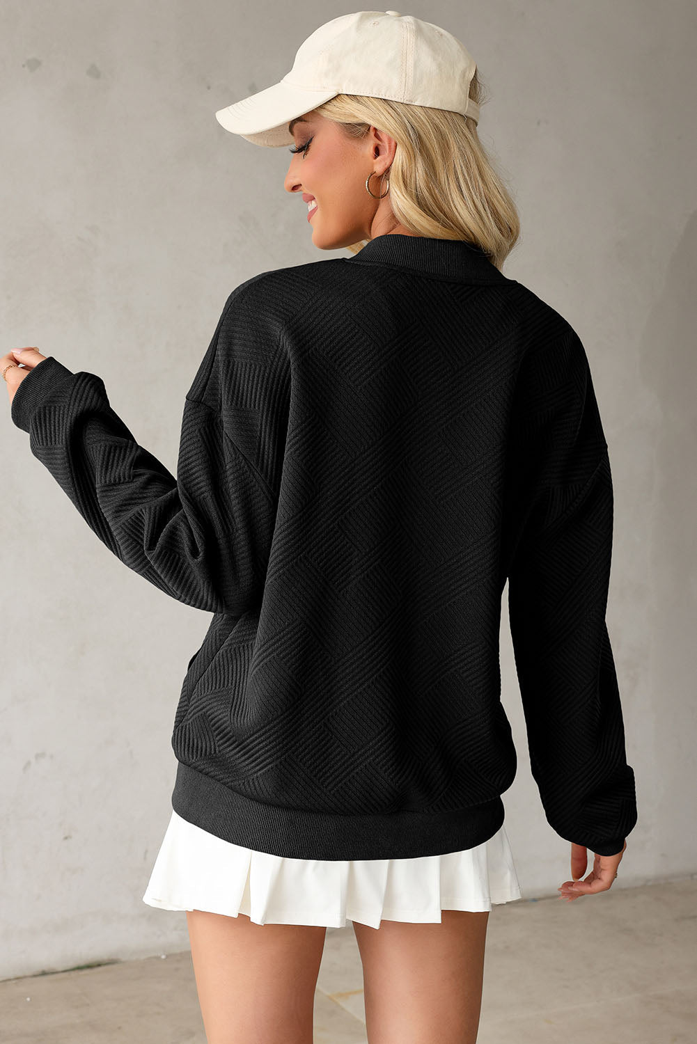 Black bomber jacket with diamond quilting and a stand-up collar.