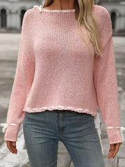 Dusty pink knit sweater with white stitched trim and bow details on neckline and cuffs.