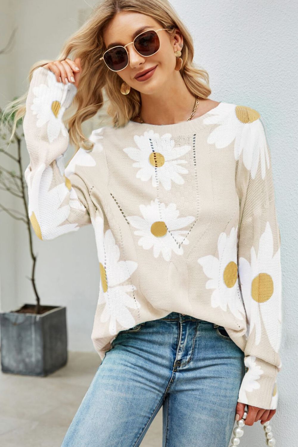Beige intarsia knit sweater with daisy pattern and crew neck.