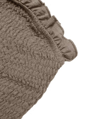 Smocked strapless wide-leg romper in taupe with frill detail and textured fabric.