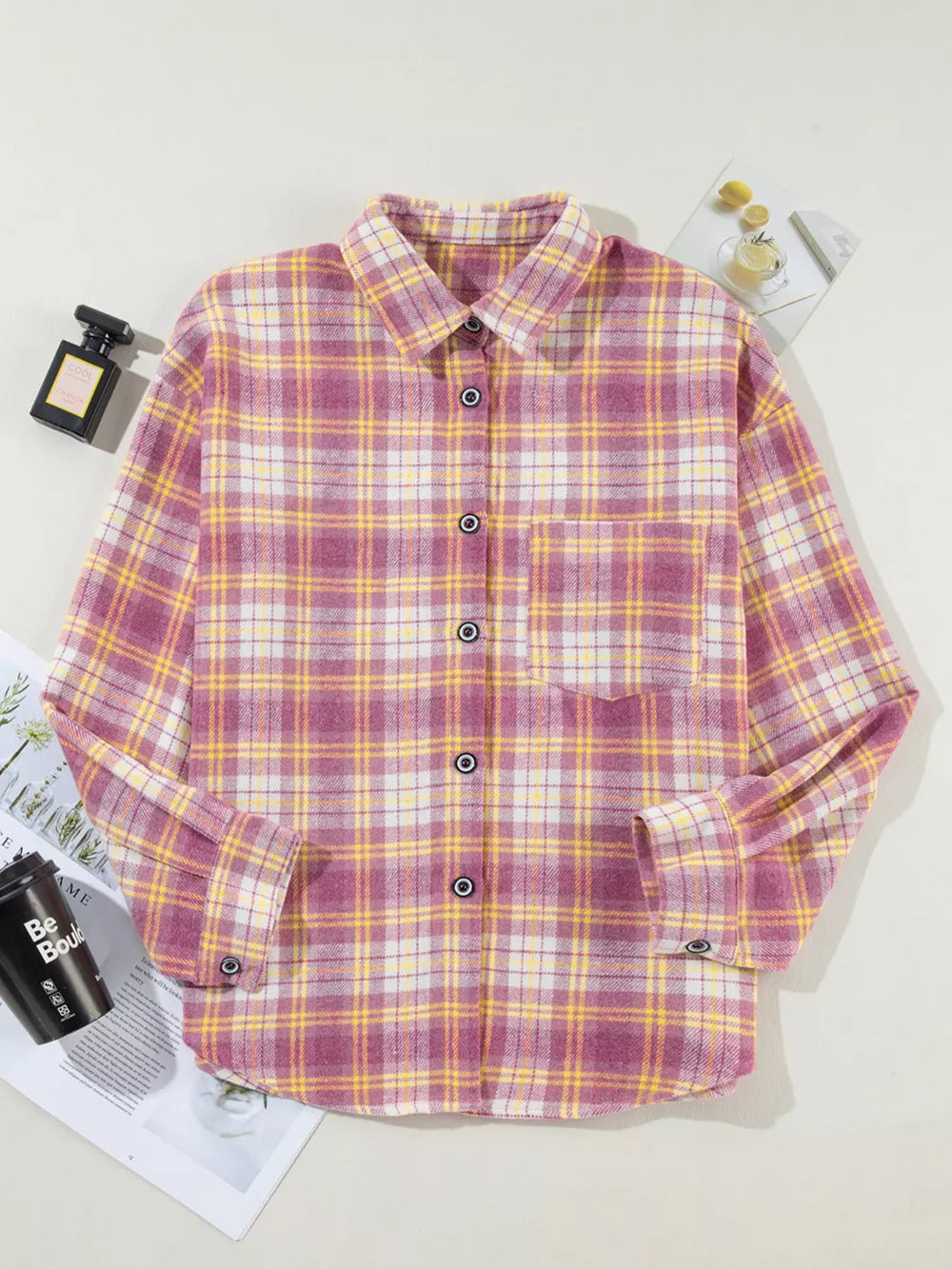 Oversized plaid shacket with pocket, classic collar, button-down front, and curved hem in pink and yellow plaid.
