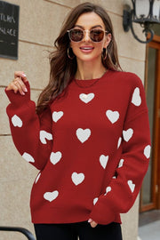 Red knit sweater with white heart pattern, crew neck, and balloon sleeves.
