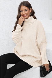 Beige ribbed turtleneck sweater with batwing sleeves and ribbed cuffs.