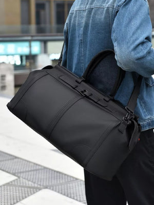 Black Oxford cloth travel duffel bag with adjustable strap and top handles.