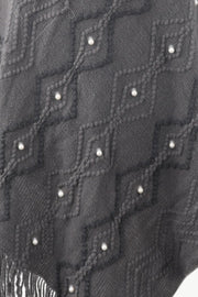 Charcoal knit poncho with geometric diamond pattern and pearl embellishments, fringed hem.
