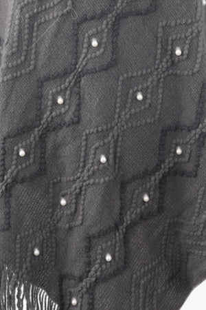 Charcoal knit poncho with geometric diamond pattern and pearl embellishments, fringed hem.